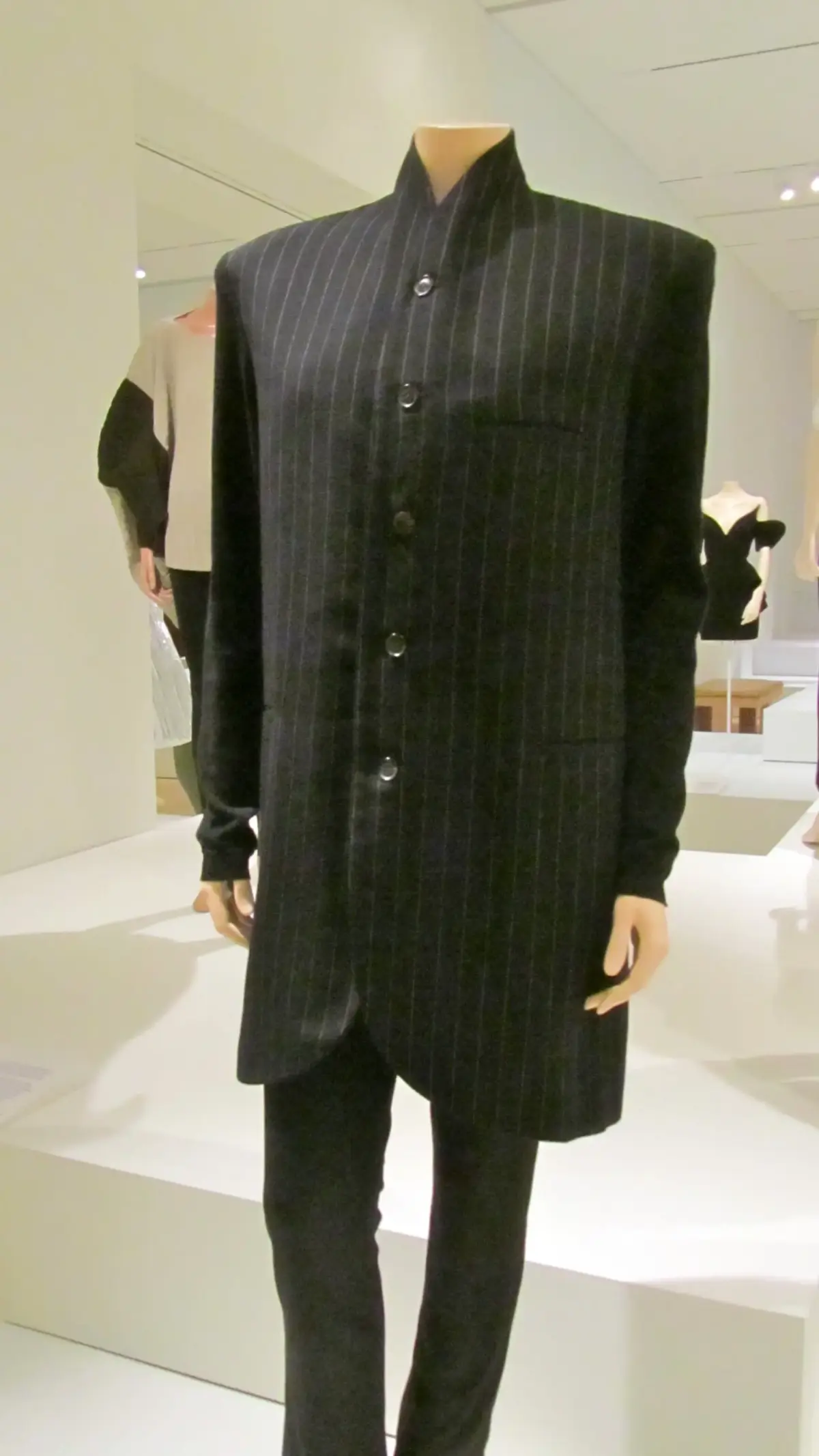 Yohji Yamamoto wool suit circa 1990 displayed on a mannequin showcasing oversized proportions, dark tailoring, and fluid silhouette