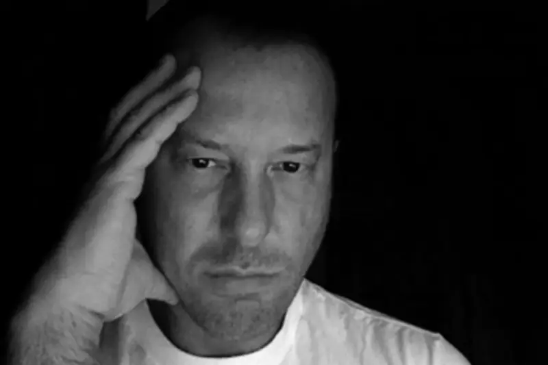 Helmut Lang self-portrait from 2007 showing the Austrian designer in austere black against a stark white wall
