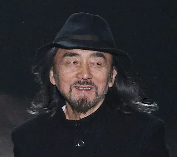Yohji Yamamoto acknowledging runway applause in black hat and coat at New York Fashion Week